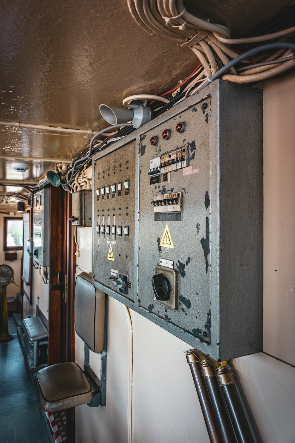 Bej bir duvara monte edilmiş iki gri elektrik kontrol paneli.